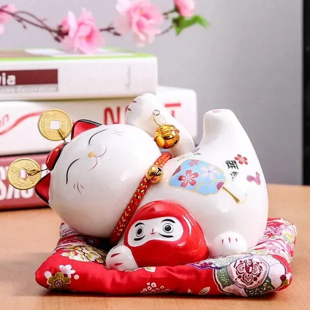 Esprit du Japon Meneki Neko couché avec Daruma tirelire